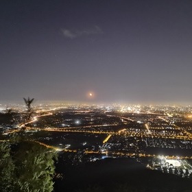 鬼笑石上俯瞰整个北京的夜景,一轮血月挂在远处的天际